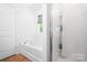 Bright bathroom with tub and shower featuring light tile floors at 9437 Macquarie Ln, Charlotte, NC 28227