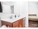 Bright bathroom with dual sinks, cherry cabinets, and leads to the Primary bedroom at 9437 Macquarie Ln, Charlotte, NC 28227
