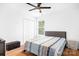 Cozy bedroom featuring wood floors, ceiling fan, and natural light from the window at 9437 Macquarie Ln, Charlotte, NC 28227
