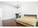 Bedroom with hardwood floors, a rustic wood bed frame, modern chandelier, and desk at 9437 Macquarie Ln, Charlotte, NC 28227