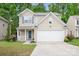 Inviting two-story home with a well-kept lawn, flower beds, and an attached two car garage at 9437 Macquarie Ln, Charlotte, NC 28227