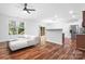 Open-concept living room with hardwood floors, a ceiling fan, and abundant natural light at 9437 Macquarie Ln, Charlotte, NC 28227