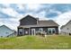 A home with gray siding, surrounded by a grassy hill under a dramatic cloudy sky at 10100 Jack Nicklaus Dr, Lancaster, SC 29720