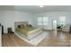 Spacious bedroom with wood flooring, a large bed, area rug, and a window with natural light at 10100 Jack Nicklaus Dr, Lancaster, SC 29720