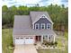 Aerial view of a charming two-story home with a well-manicured lawn, two-car garage, and a cozy front porch at 10100 Jack Nicklaus Dr, Lancaster, SC 29720