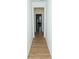 Hallway with wood flooring leading to an open door and a bright living area with indoor plants at 10100 Jack Nicklaus Dr, Lancaster, SC 29720
