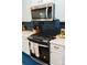 Kitchen with stainless steel microwave and range with dark blue patterned backsplash and white cabinets at 10100 Jack Nicklaus Dr, Lancaster, SC 29720