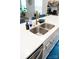 Kitchen island featuring a stainless steel sink, gold faucet, white countertop, and blue flooring at 10100 Jack Nicklaus Dr, Lancaster, SC 29720