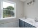 Bathroom featuring a double sink vanity with white countertops and a garden window with a backyard view at 1013 Doby Springs Dr, Charlotte, NC 28262