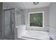 Bright bathroom featuring a marble tiled shower, tub, and a garden window with natural lighting at 1013 Doby Springs Dr, Charlotte, NC 28262