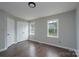 Neutral bedroom featuring two windows, dark wood flooring, and a closet at 1013 Doby Springs Dr, Charlotte, NC 28262