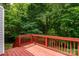 Red-stained deck offering a peaceful spot surrounded by lush greenery at 1013 Doby Springs Dr, Charlotte, NC 28262