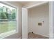 Bright laundry room featuring a large window, tile flooring, and a wire shelf at 1013 Doby Springs Dr, Charlotte, NC 28262