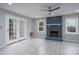 Cozy living room featuring a painted brick fireplace, white trim, and modern ceiling fan at 1013 Doby Springs Dr, Charlotte, NC 28262