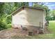 View of the home's siding and foundation with an overgrown lawn at 1016 W 10Th Ave, Gastonia, NC 28052
