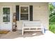 Close up of a home's inviting front porch with bench seating and a welcoming sign at 1016 W 10Th Ave, Gastonia, NC 28052