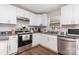 Well-lit kitchen with stainless steel appliances, granite counters, white cabinetry and wood-look floors at 1016 W 10Th Ave, Gastonia, NC 28052
