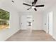 Bright bedroom featuring wood-look flooring, a ceiling fan, and an open doorway to an all-white kitchen at 1155 Cedar Grove Ln, Rock Hill, SC 29732