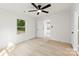 Bright bedroom with wood-look floors, a ceiling fan and windows, plus an open doorway to the kitchen at 1155 Cedar Grove Ln, Rock Hill, SC 29732