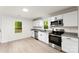 Well-lit kitchen with stainless steel appliances, white cabinetry, granite countertops, and light hardwood floors at 1155 Cedar Grove Ln, Rock Hill, SC 29732