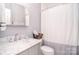 Bathroom featuring a white vanity with a marble countertop and tiled shower with shower curtain at 11772 Sugar Hill Rd, Davidson, NC 28036