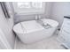 Freestanding tub in a bright bathroom with marble floors and grey walls at 11772 Sugar Hill Rd, Davidson, NC 28036