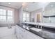 Bright bathroom with double sink vanity, granite counters, large mirror and tub at 11772 Sugar Hill Rd, Davidson, NC 28036
