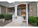Inviting front entrance with stone accents, white pillars, and a charming wooden door, offering curb appeal at 11772 Sugar Hill Rd, Davidson, NC 28036