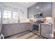 Charming kitchen with stainless steel appliances, gray cabinetry, granite countertops, and backsplash tiles at 11772 Sugar Hill Rd, Davidson, NC 28036