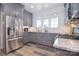 Well-lit kitchen featuring gray cabinets, granite countertops, stainless steel appliances, and wood-look flooring at 11772 Sugar Hill Rd, Davidson, NC 28036
