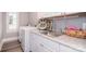 Bright laundry room with white cabinetry, granite counters, and a stainless steel sink, next to a washer and dryer at 11772 Sugar Hill Rd, Davidson, NC 28036