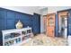 Living room featuring blue wood-paneled walls and colorful rug with decorative shelf at 11772 Sugar Hill Rd, Davidson, NC 28036