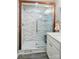 Updated bathroom with a marble tiled shower, glass door, and updated fixtures at 118 Globe St, Mount Holly, NC 28120