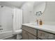 Modern bathroom featuring a shower-tub combo with tiled walls and gray vanity at 118 Globe St, Mount Holly, NC 28120