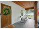 Inviting front porch with seating, a stained wood ceiling, a lovely front door and a cheerful welcome mat at 118 Globe St, Mount Holly, NC 28120
