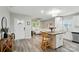 Open-concept living space featuring a modern kitchen with white cabinets, a center island, and sleek, light-colored flooring at 118 Globe St, Mount Holly, NC 28120