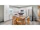 Modern kitchen featuring white cabinets, stainless steel appliances, a center island with seating, and sleek, light-colored flooring at 118 Globe St, Mount Holly, NC 28120