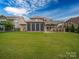 Spacious green backyard with a screened-in porch, outdoor kitchen under a pergola, perfect for entertaining at 1190 Arges River Dr, Fort Mill, SC 29715