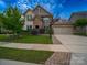 Attractive two-story home with brick and stone, complemented by a lush lawn and a basketball hoop above the garage at 1190 Arges River Dr, Fort Mill, SC 29715