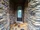 Inviting front door framed by stone, accented by stone flooring and offering a glimpse of the landscaped front yard at 1190 Arges River Dr, Fort Mill, SC 29715