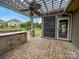 Backyard featuring an outdoor kitchen with a built-in grill, stone facade, and a mini fridge, under a pergola at 1190 Arges River Dr, Fort Mill, SC 29715