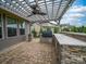 Covered outdoor kitchen featuring a grill, stone accents, and a ceiling fan, ideal for alfresco dining at 1190 Arges River Dr, Fort Mill, SC 29715