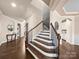 Elegant staircase with dark wood treads and iron balusters, leading to upper level, with hardwood floors at 1190 Arges River Dr, Fort Mill, SC 29715