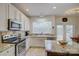 Bright kitchen featuring stainless appliances, granite countertops, and a convenient island at 12125 Mountainside Ln, Charlotte, NC 28278
