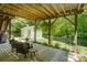 Relaxing covered patio with comfortable seating overlooks a well-manicured lawn and storage shed at 12125 Mountainside Ln, Charlotte, NC 28278