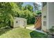 Charming storage shed with decorative shutters and lush greenery in a private backyard at 12125 Mountainside Ln, Charlotte, NC 28278