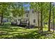 Large backyard with a wooden deck, stairs, mature trees providing ample shade, and green grass at 12602 Angel Oak Dr, Huntersville, NC 28078