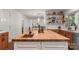 Large kitchen island with sink, butcher block countertop, hardwood floors, and open to the living area at 12602 Angel Oak Dr, Huntersville, NC 28078