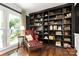 Library with dark shelves, wooden floors and a red tufted chair at 12602 Angel Oak Dr, Huntersville, NC 28078