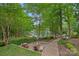 A backyard oasis with a stone patio, fire pit, and lush greenery creating a relaxing outdoor space at 166 Pinnacle Shores Dr, Mooresville, NC 28117